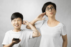 preteen boy and mom listen to music together from earphones