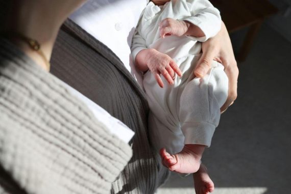 mother carrying young infant in arm