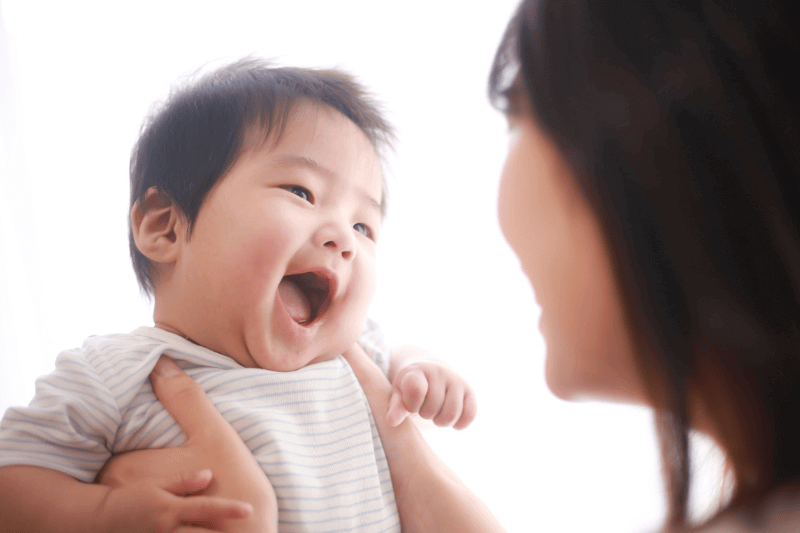 image of young infant happy being carried by mother 