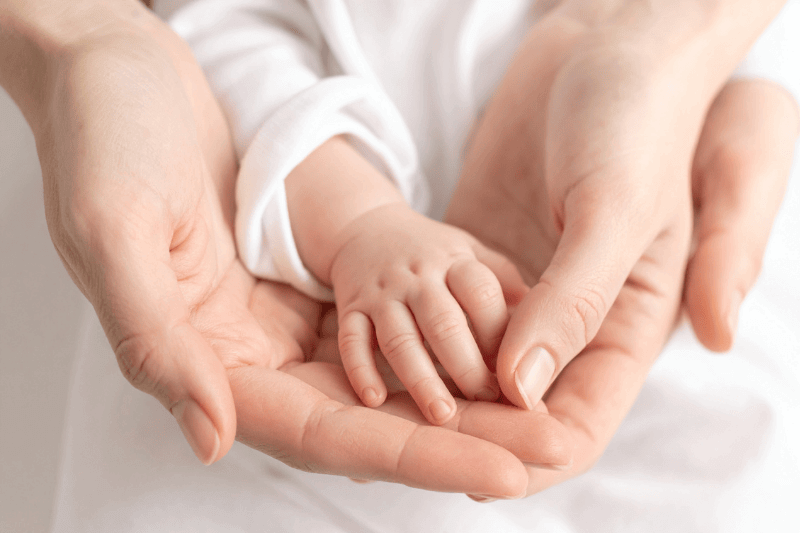 infants hand holding mothers hand in parent and child photoshoot 