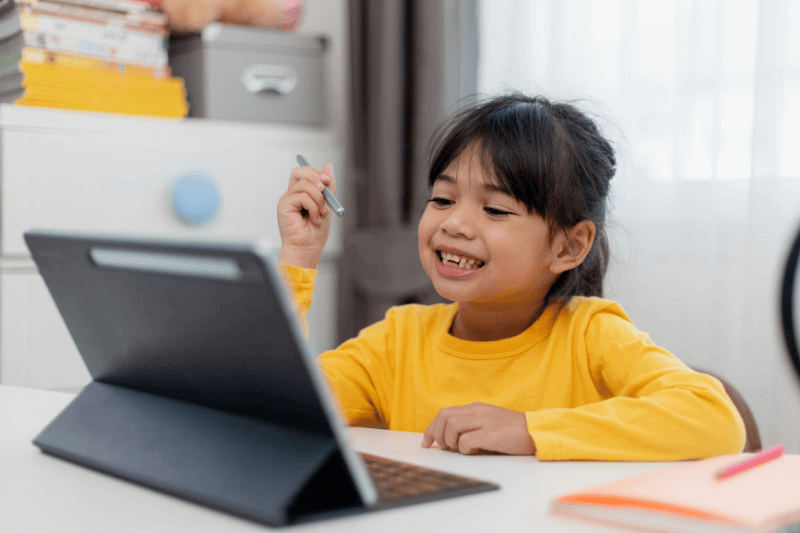 schoolgirl doing her homework with digital tablet at home