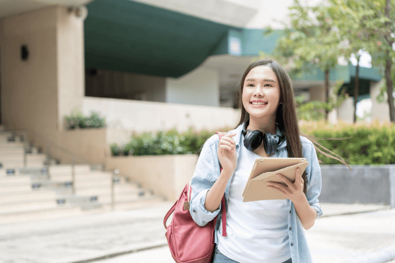 asian woman with backpack and books outdoor university student