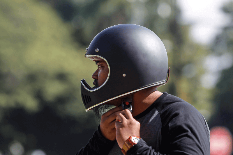 close up Man tries to put off his helmet after riding motorbike