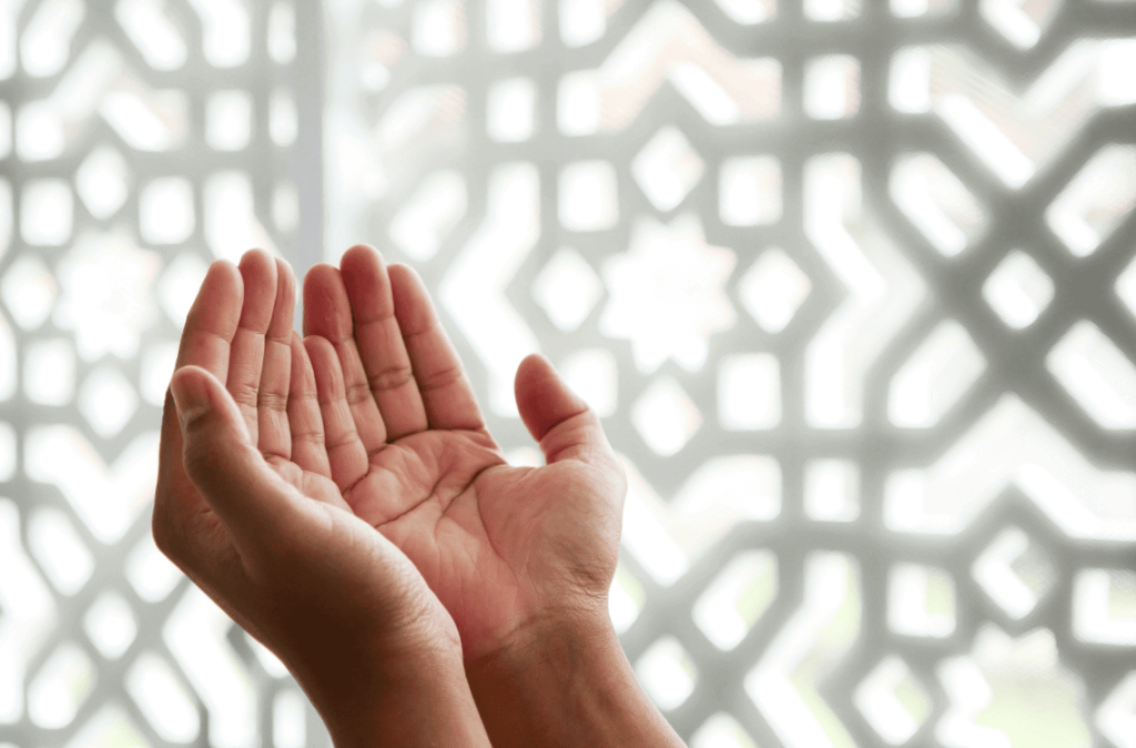 Close-up of person's hands praying in a mosque with Islamic geometric pattern background. Concept of faith, Ramadan, and spirituality