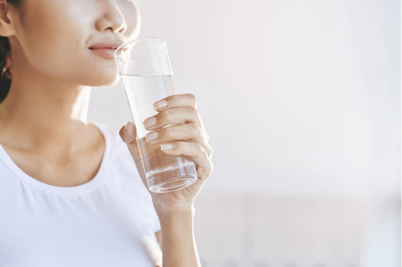 image of woman drinking water indicating importance of hydration