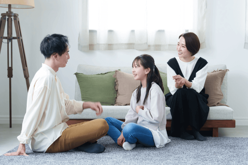 young asian family relaxing in living room, talking to each other.