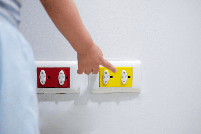 Curious Asian toddler child play with electric plug