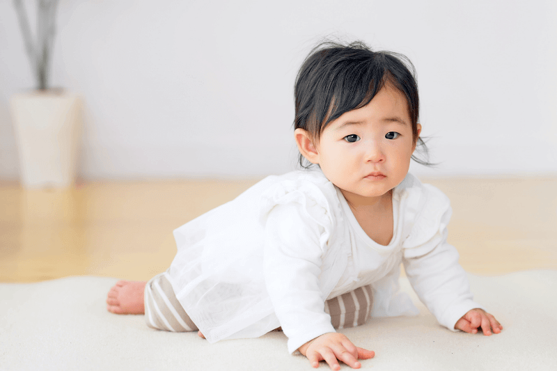 Baby crawling on floor in room.
