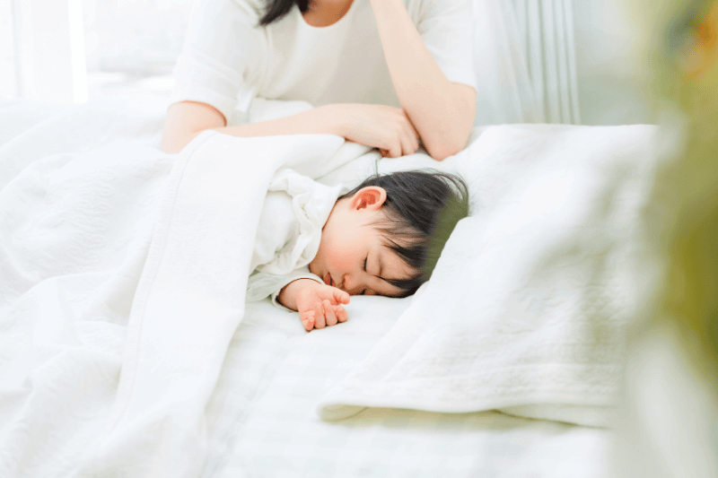 young child lying down in bed