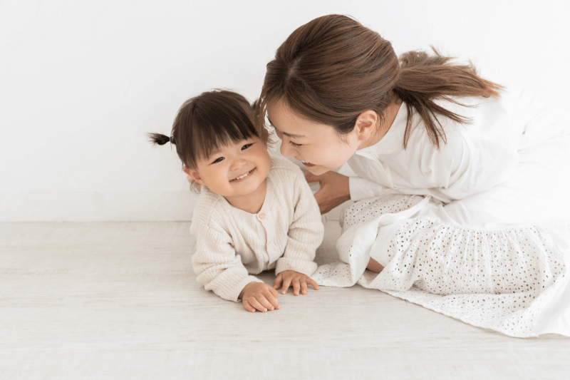 young girl practicing tummy time with mother