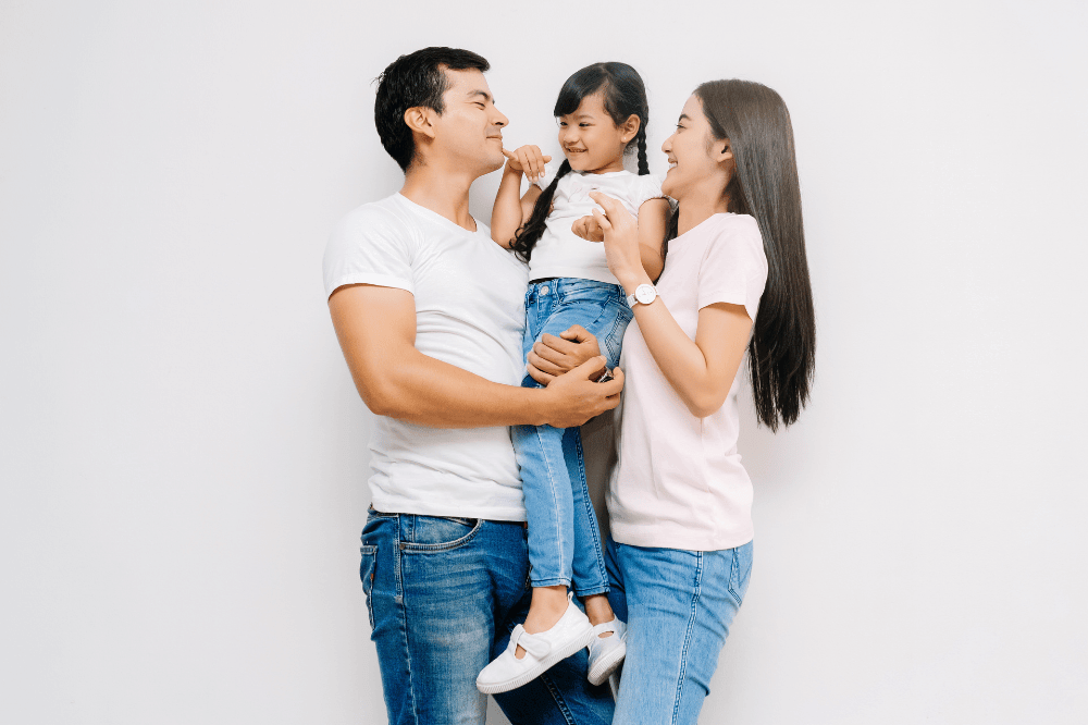 family of three enjoying time together child being carried by father
