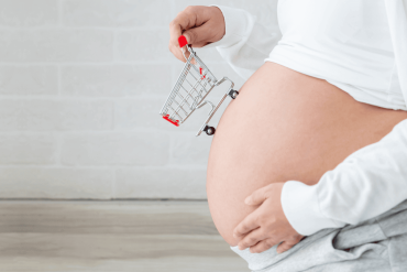 Pregnant women buy baby products and holding shopping cart, Pregnancy shopping item for children concept