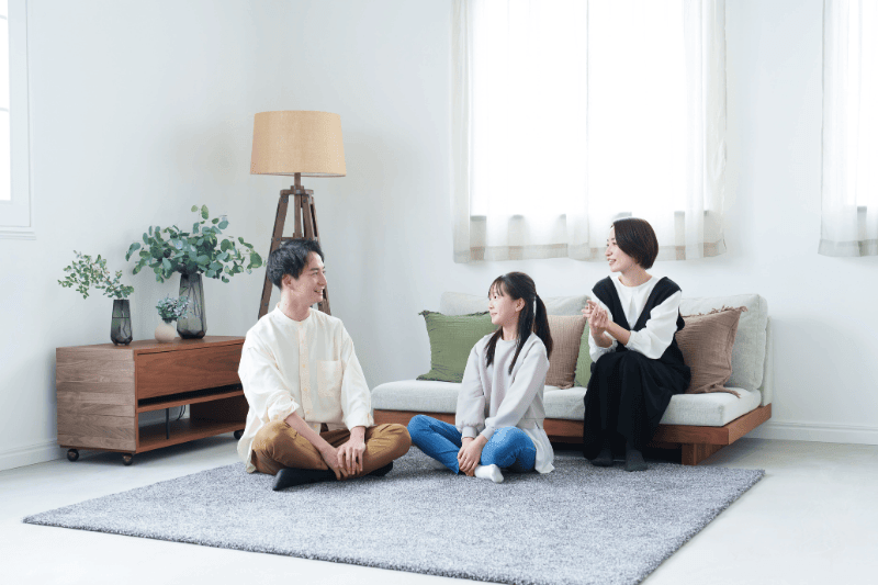 young asian family relaxing in living room, talking to each other.