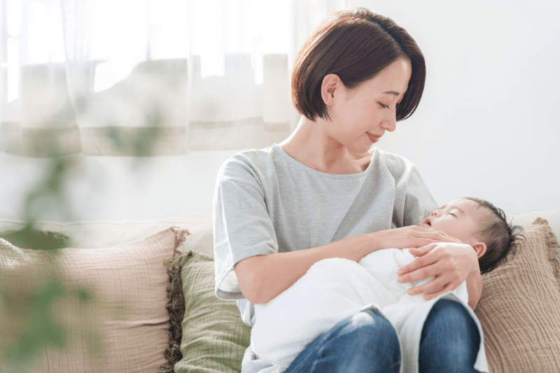 mum holding and swaddling young baby