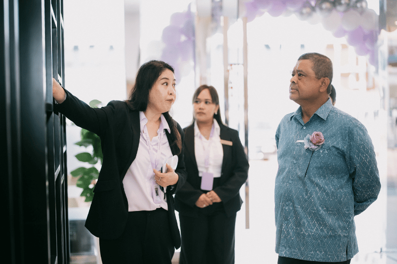 woman showing tour of a clinic to a man wearing malaysian batik medical tourism