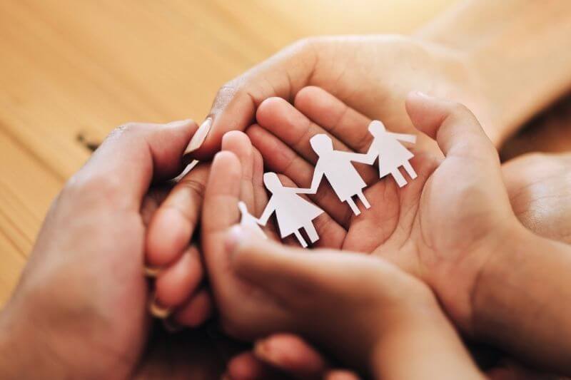 two parents and child holding a cutout of family to showcase family planning