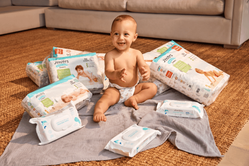 Baby in diaper sitting on floor