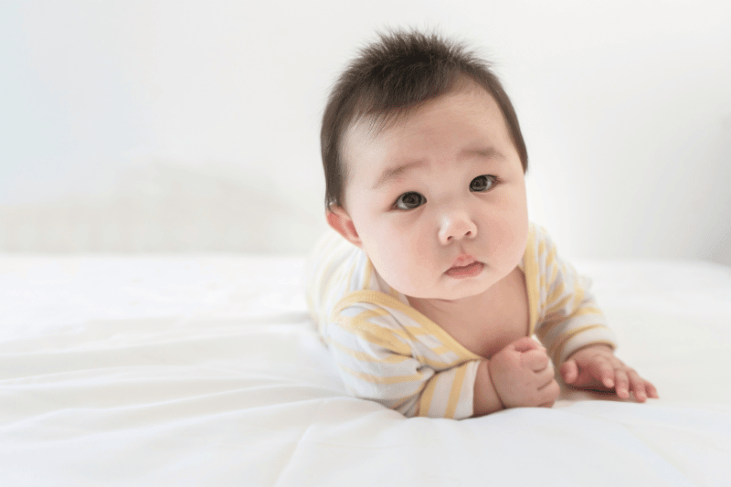 Cute infant child crawling on bed in the bedroom.