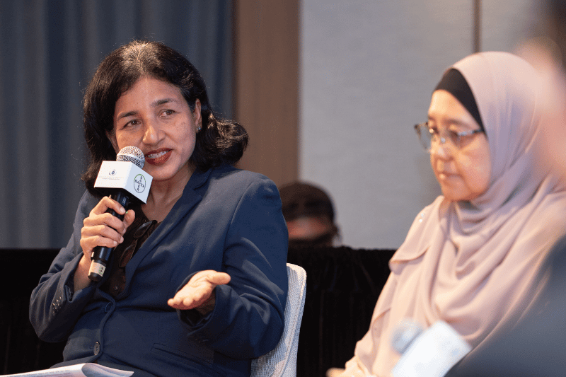 medical doctor speaking on stage with mic in hand