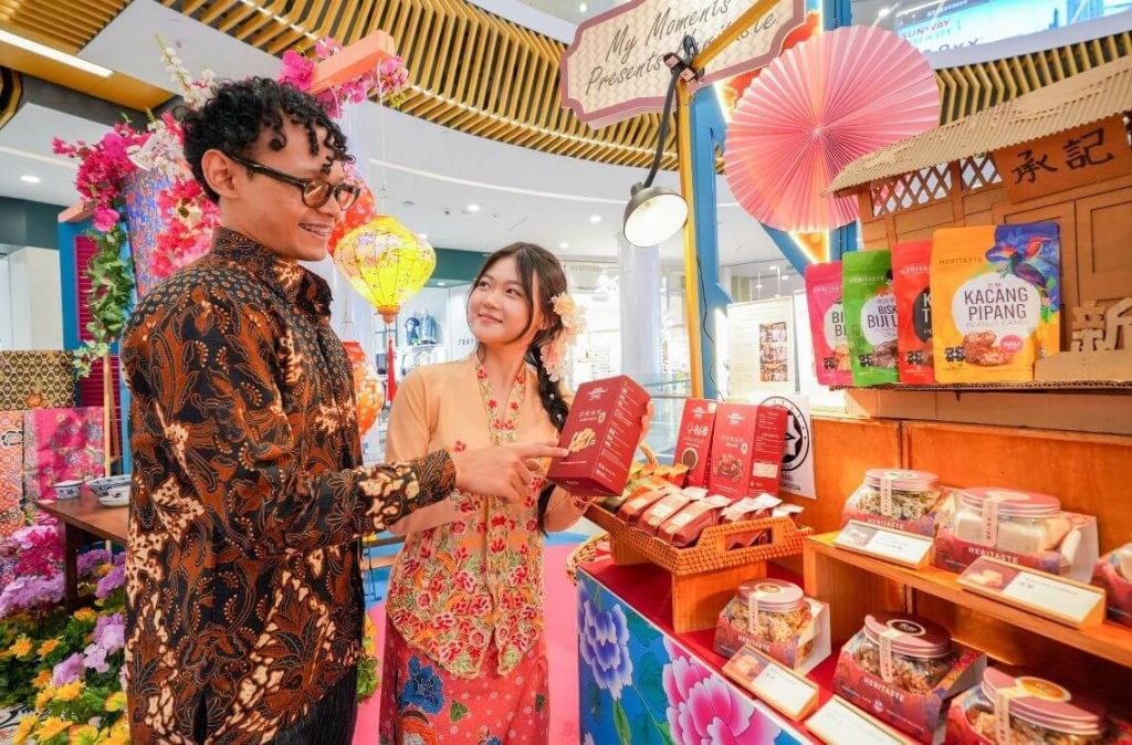 a man wearing batik at the mall with a woman wearing kebaya during a peranakan nyonya festival