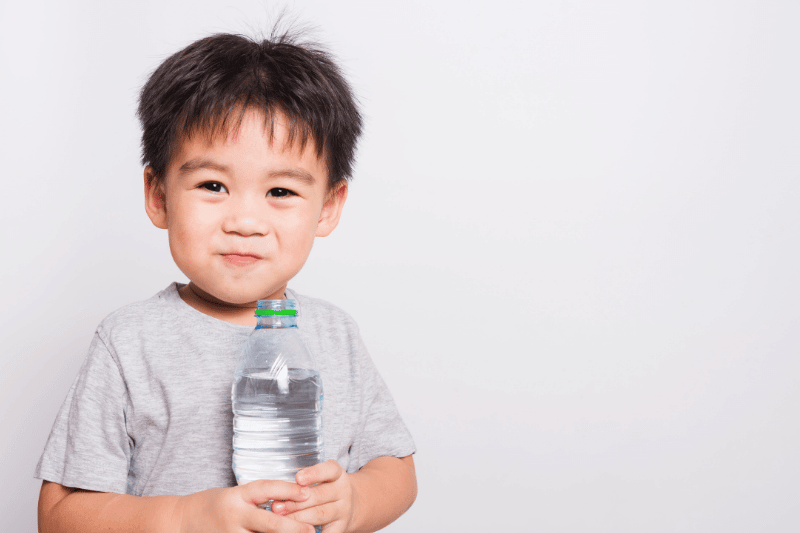 Closeup Asian face, Little children boy drinking water from Plastic bottle on white background with copy space, health medical care