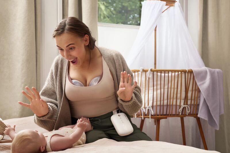 mum pumping with wireless pump and bonding with baby