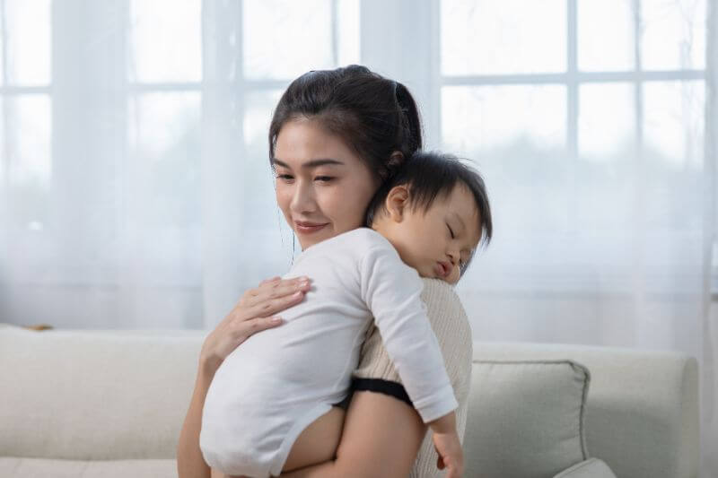 mother holding a cute newborn baby sleep on arm comfort and safety.