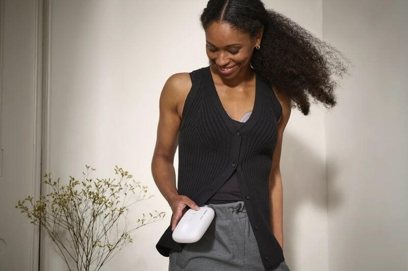 woman using wireless breastpump while enjoying being mobile and free to move