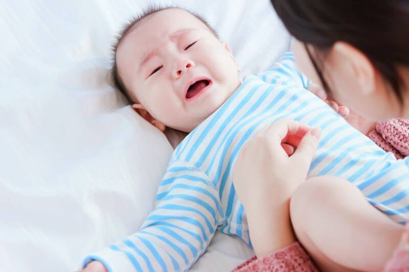 asian baby lying on the bed and crying