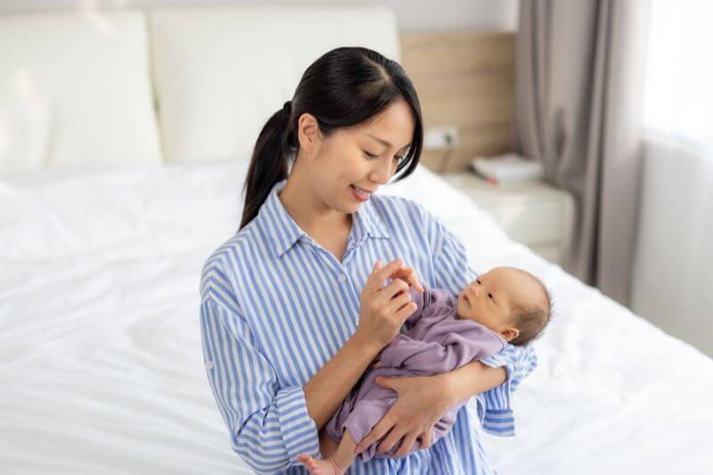 Asian mom play with newborn baby