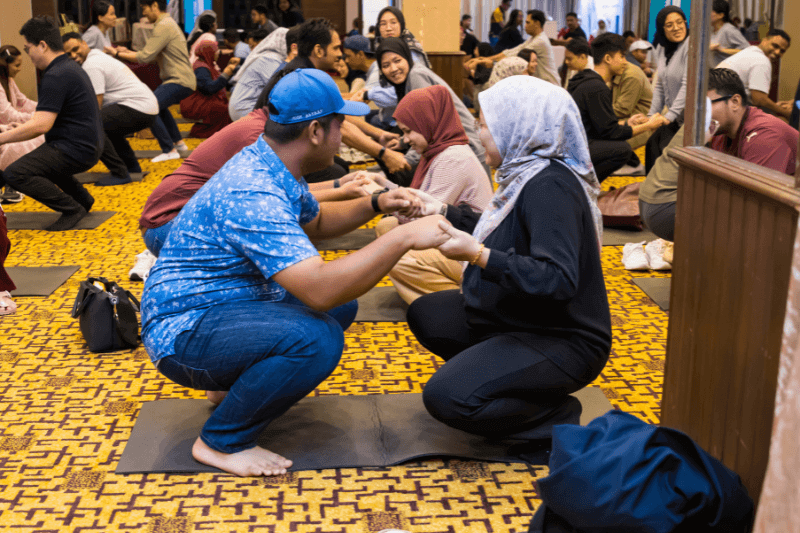 Partner-assisted stretching exercise at Malaysia Tourism Family Active and Wellness Expo