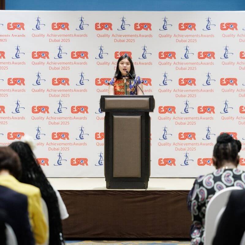 woman on podium giving speech at awards ceremony