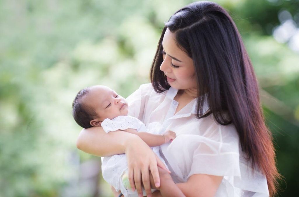 Portrait of happy loving mother and her baby outdoors, Asian girl lifestyle. Asia mother's day concept