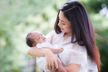 Portrait of happy loving mother and her baby outdoors, Asian girl lifestyle. Asia mother's day concept