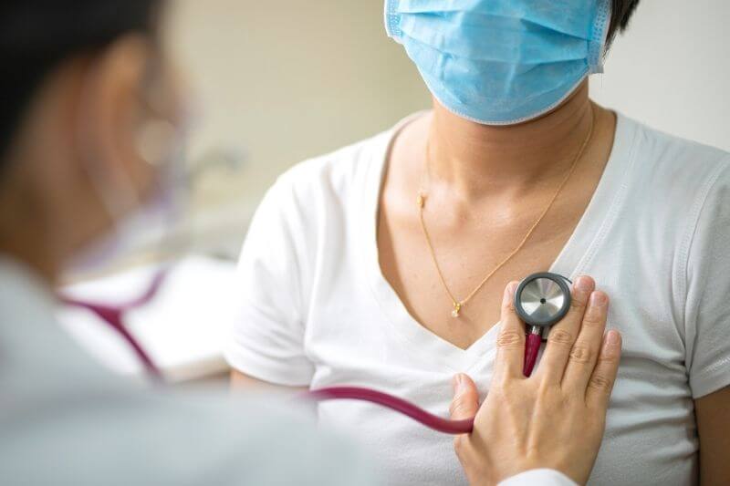 Female doctor using stethoscope exam Asian female patient for physical examine pneumonia lung sound checkup in hospital. Coronavirus, covid-19, medical and healthcare concept