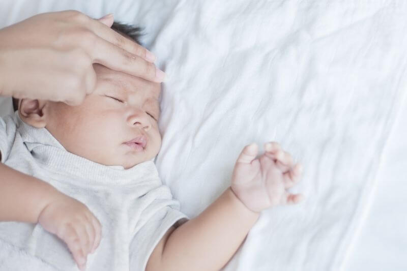 Mother Checks The Temperature Of A Sick Baby, newborn baby had a fever. Healthcare medical concept