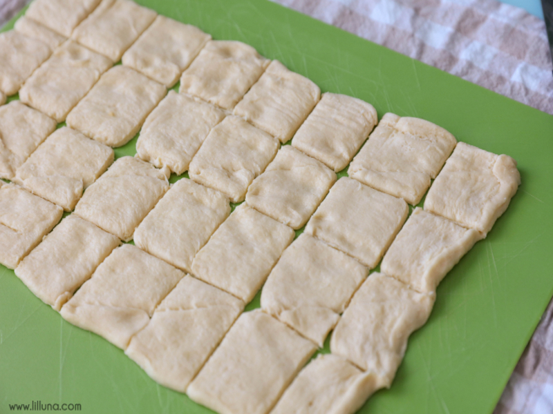 crescent dough rolled out on a cutting board and cut into strips