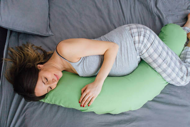 wanita hami tidur dengan bantal materniti