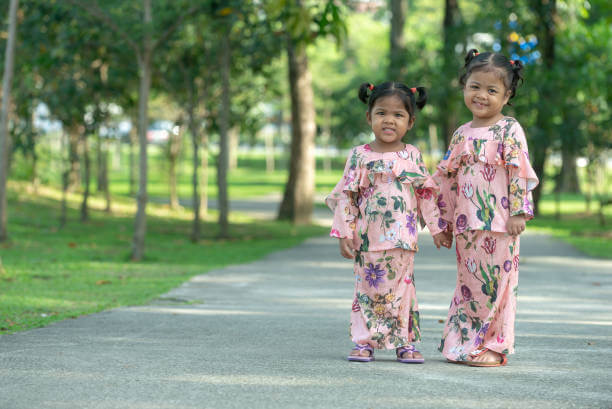 dua anak perempuan berbaju kurung di taman