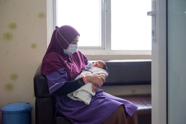 jururawat memegang bayi di klinik ibu dan anak 