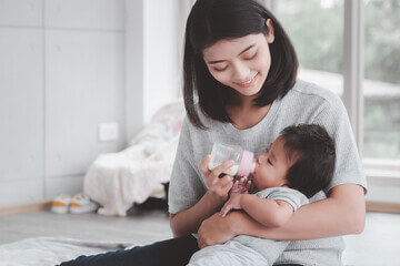 ibu suapkan susu soya untuk bayi