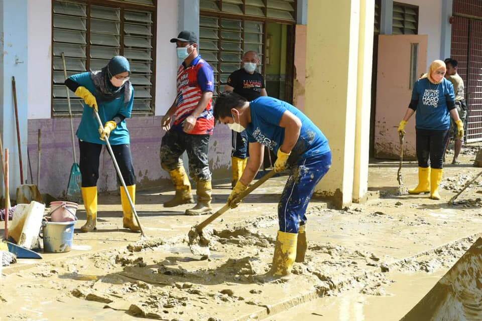 Datuk Dr. Mohd. Radzi bin Md. Jidin membantu membersihkan sekolah yang terjejas akibat banjir