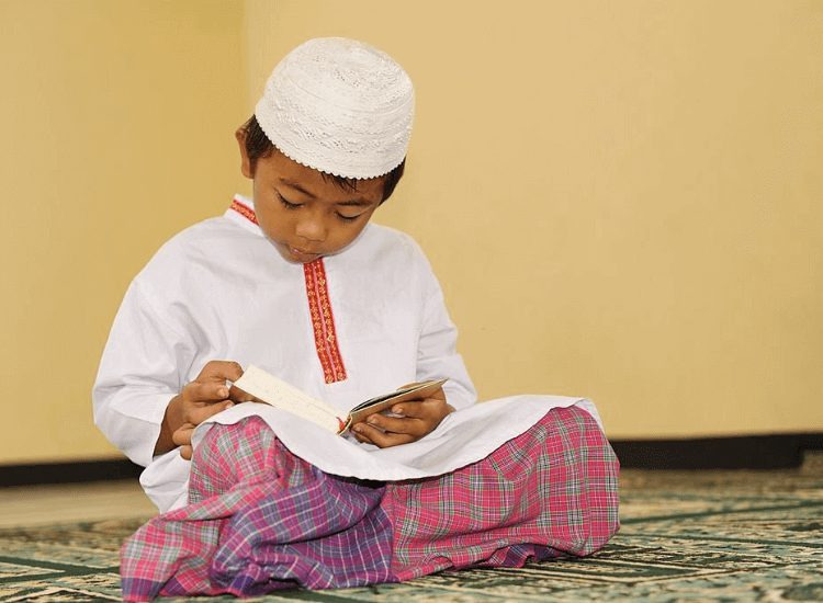 kanak-kanak lelaki membaca al-quran dan mengamalkan doa kuat ingatan