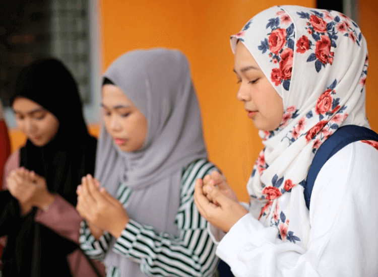 tiga orang perempuan berdoa 