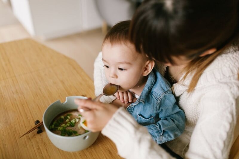 ibu suapkan sup ayam sebagai cara hilangkan selesema bayi