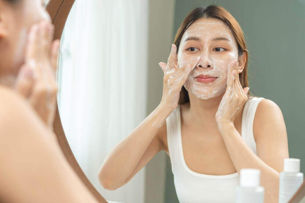 wanita sedang exfoliate muka untuk mengelak punca kulit kusam