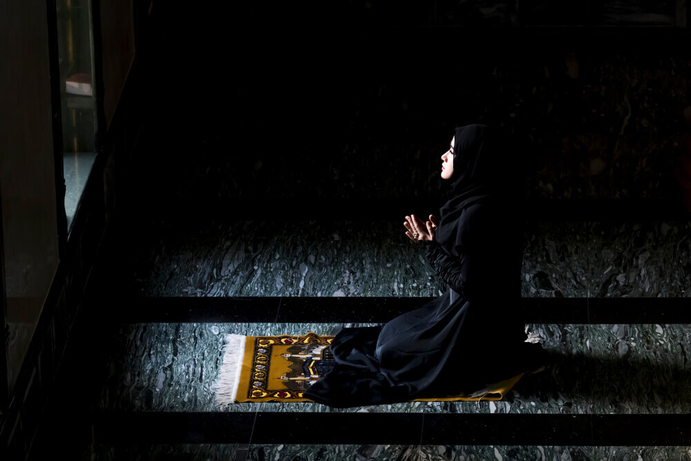 wanita sedang membaca doa selepas solat untuk merawat hati hitam